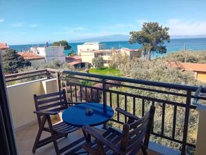 a balcony with two chairs and a blue table at Nikis studios in Skala Sotiros