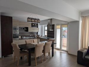 a kitchen and dining room with a table and chairs at Apartament central 3 dormitoare in Târgu Secuiesc