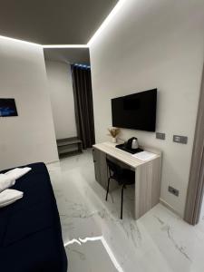 a hotel room with a desk and a tv at Blue Seagull Guest House in Chiavari