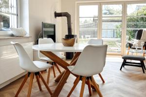 Un comedor con una mesa y sillas blancas. en Ferienhaus NATÜRLICH AM BODDEN, en Michaelsdorf