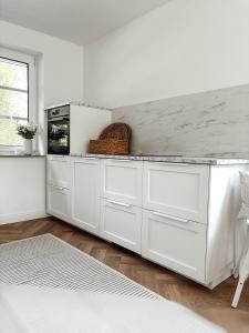 Una cocina con gabinetes blancos y encimera. en Ferienhaus NATÜRLICH AM BODDEN, en Michaelsdorf