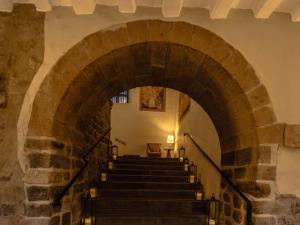 a staircase in a building with a stone archway at Novotel Cusco in Cusco