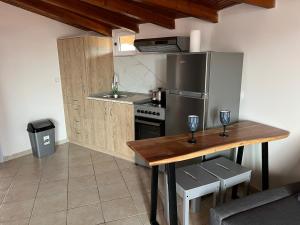 Una cocina con una mesa y un refrigerador de acero inoxidable. en Sweet Home Wooden, en Kastoria 19 fotos más