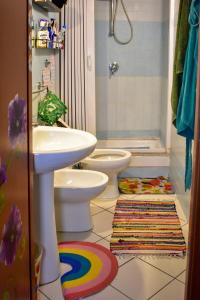 a bathroom with a sink and a toilet and a rug at Bed-Letto-Cama in Shared Room Camera Condivisa in Naples