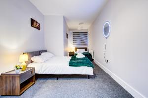 a bedroom with a bed and a desk with a mirror at 2 BR Flat 6 Mins From Heathrow Airport Flat 41 in Harmondsworth