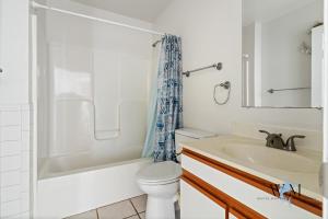 a white bathroom with a toilet and a sink at Charming 3-Bedroom, 2-Bathroom Townhouse Perfectly Located Near the Boardwalk in Ocean City +31 photos