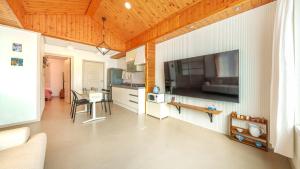 a kitchen with a large flat screen tv on the wall at Sokcho Seohyeon Ine Pension in Sokcho