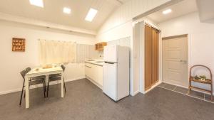 cocina con mesa pequeña y nevera en Sokcho Seohyeon Ine Pension, en Sokcho