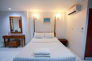 a hotel room with a bed and a desk at 18 Coins Budget Hotel in Pattaya Central +39 photos