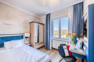 a hotel room with a bed and a window at Strandhotel Löchnerhaus in Reichenau