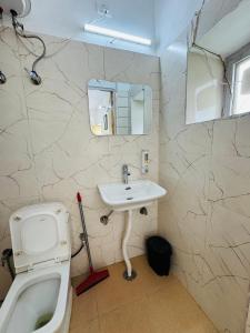a bathroom with a sink and a toilet at Suwakholi Farms in Mussoorie