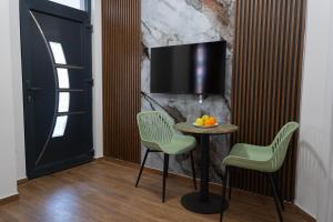 a room with a table and two chairs and a tv at Urban Stay - Main Area Apartments in Skopje