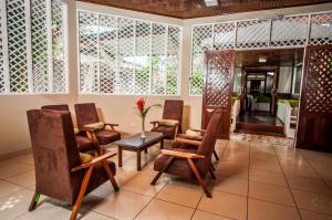 vestíbulo con sillas, mesa y habitación en Hotel Cabaña Quinta, en Puerto Maldonado