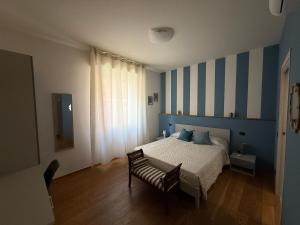 a bedroom with a bed with blue and white stripes at Rooms primo piano in Modena