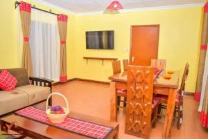 a living room with a table and a dining room at Nyokal Travellers Inn in Kendu Bay