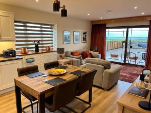 a kitchen and living room with a table and a couch at Dalchalm Hideaway in Brora