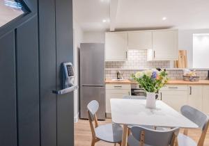 eine Küche mit Tisch und Stühlen und einem Kühlschrank in der Unterkunft Carpenters Cottage - The Lakes! in Kendal