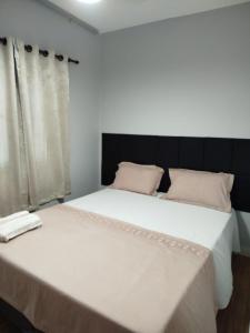 Dos camas una al lado de la otra en un dormitorio. en Paraíso no Jockey de Itaparica, en Vila Velha