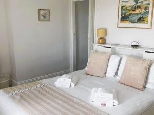 a white bed with two towels on top of it at Coastguard Cottage in Ventnor +47 photos