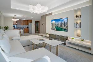 un salon avec un canapé blanc et une télévision dans l'établissement 49 - Dubai Marina Sea View - High Floor Apartment - Princess Tower, à Dubaï
