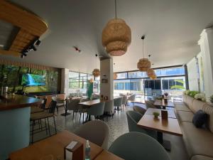 a restaurant with tables and chairs and windows at Rodis hotel in Gumuldur