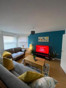 ein Wohnzimmer mit Sofa und Fernseher in der Unterkunft Horizon Vista in Ilfracombe