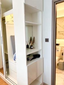 a white closet with white shelves in a room at The Astra Sky River Luxury Condo,the largest pool in Chiang Mai