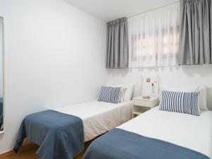 ein Hotelzimmer mit zwei Betten und einem Fenster in der Unterkunft Ciaboga Front Line By CanariasGetaway in San Agustín + 49 Fotos