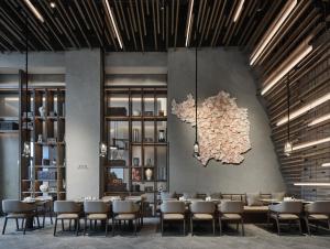 a restaurant with tables and chairs and a map on the wall at Wanda Realm Yan'an in Yan'an