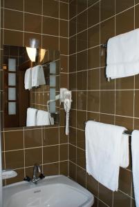 a bathroom with a sink and a mirror and towels at Hotel Garni Maximilian in Zell am Ziller