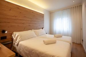 a bedroom with two beds and a wooden headboard at Plaza Obradoiro Express by Bossh! Hotels in Santiago de Compostela