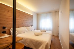 a hotel room with two beds and a wooden wall at Plaza Obradoiro Express by Bossh! Hotels in Santiago de Compostela