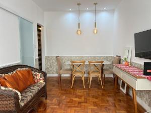 a living room with a couch and a table and chairs at Vista Lateral Mar Fique No Melhor Lugar da Praia in São Vicente