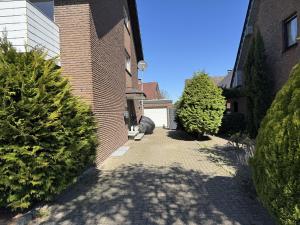 a brick building with a walkway between two trees at Gemütliches Kellerzimmer + Bad in Bocholt