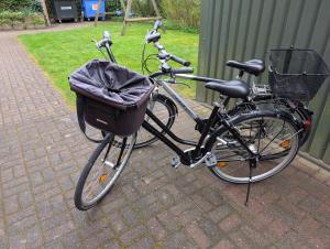a bike with a basket parked on a brick sidewalk at Klein Erna (Apth.Holländerei) in Büsum
