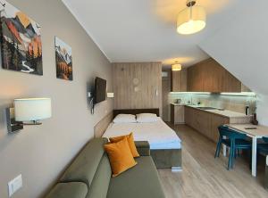 a small room with a bed and a kitchen at Willa na Orlej in Giewartów