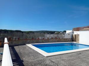 a swimming pool in a yard with a fence at Matilde&Leire in Barbate