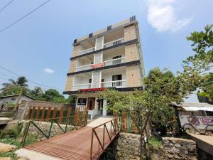 古瓦哈提Hotel Riva Inn的前面有木人行道的高楼