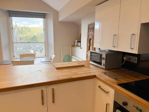 a kitchen with a counter with a microwave and a window at Lanty Scar - Amazing Views! in Ambleside +5 photos