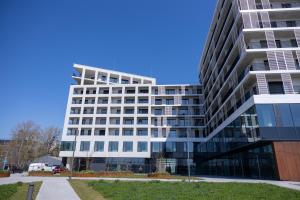 ein hohes weißes Bürogebäude mit blauem Himmel in der Unterkunft Apartmán LEON - FREE GARAGE PARKING in Bratislava