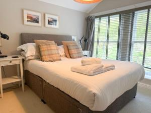 a bedroom with a large bed with towels on it at Lanty Scar - Amazing Views! in Ambleside