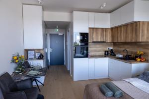 eine Küche und ein Wohnzimmer mit Sofa und Tisch in der Unterkunft Apartmán LEON - FREE GARAGE PARKING in Bratislava