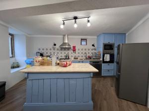 a kitchen with blue cabinets and a blue island in it at Perquilhas House in Freixial do Campo