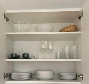 a pantry with plates and wine glasses on shelves at Oaza Narave Apartment, Peaceful Retreat near Bled & Vintgar in Spodnje Gorje +22 photos