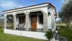 a small white house with a porch and a door at Casa Chrysi in Mesimvría