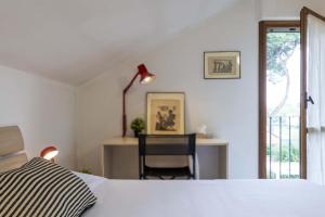 a bedroom with a bed and a desk with a chair at Italian Experience-Villa Monte Gabberi in Pietrasanta