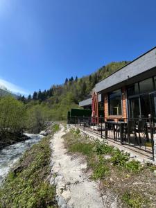 Un edificio con mesas y sillas al lado de un río. en 4M Ayder, en Ayder
