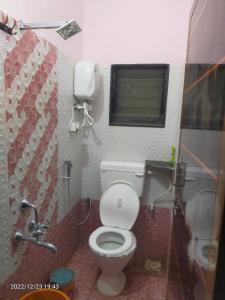 un piccolo bagno con servizi igienici e finestra di Saurabh Guest House, Akkalkot a Akalkot Altre 20 foto