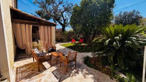 a patio with chairs and a table in a yard at Le Beldi, Mas de Village 1870 in Saint-Saturnin-lès-Avignon