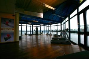 a gym with a large room with wood floors and windows at Dakar Living Hotel Vasto in Vasto